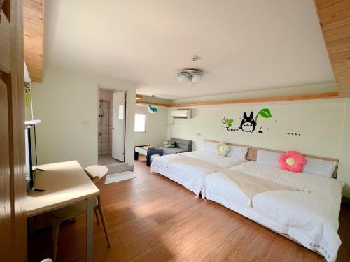 金城蛋宝亲子民宿 的卧室配有一张大白色床,墙上挂着鲜花