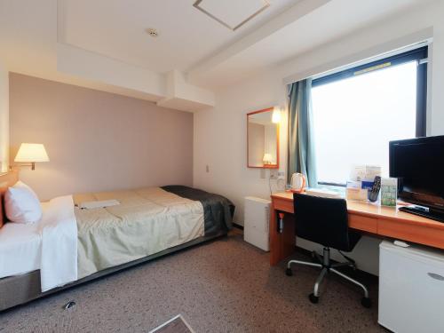 东京东京赤羽超级酒店的酒店客房配有一张床和一张带电脑的书桌