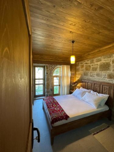 格克切达镇KİNZİ İMROZ的一间卧室设有一张木天花板床。