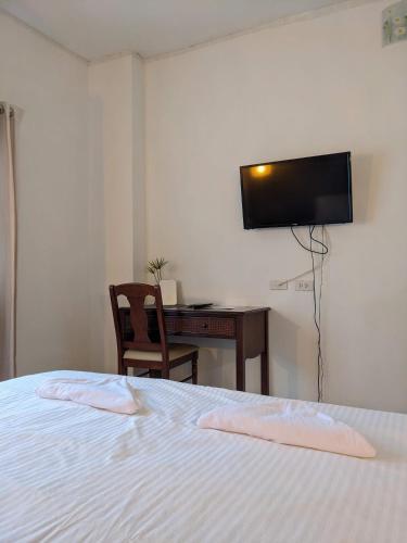 Phanat NikhomV at Panus的一间卧室配有一张床、一张书桌和一台电视