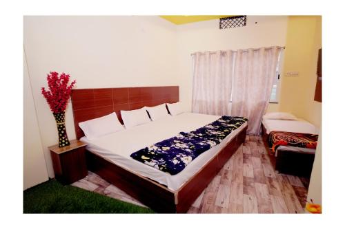 乌贾因Rajdarshan Hotel的一间卧室,配有一张床和花瓶