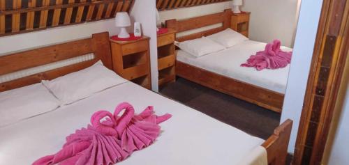 BîrladHostel INTIM 95 RON的客房内的两张床和粉红色的毛巾