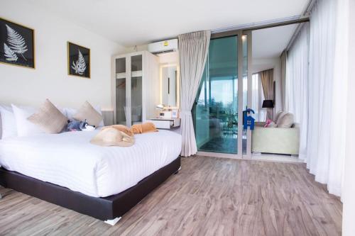 卡马拉海滩Oceana Phuket的一间卧室设有一张大床和一个滑动玻璃门