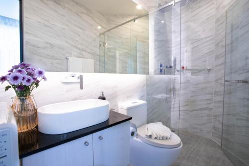 卡马拉海滩Oceana Phuket的浴室配有卫生间、盥洗盆和淋浴。