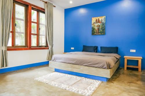 暹粒The Big Easy Siem Reap的蓝色的卧室,配有床和蓝色的墙壁