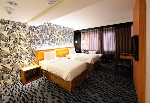 高雄泓扬精致商旅的酒店客房设有两张床和一台平面电视。