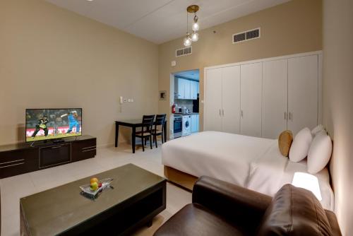 迪拜City Stay Residences - Serviced Apartments DIP的一间卧室配有一张床、一张沙发和一台电视。