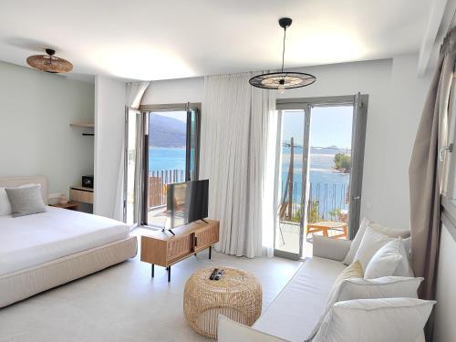 特里佐尼亚Trizonia Mare Suites的一间卧室配有一张床,客厅享有美景。