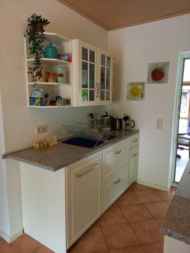 HornburgDas kleine Haus的厨房配有白色橱柜和台面