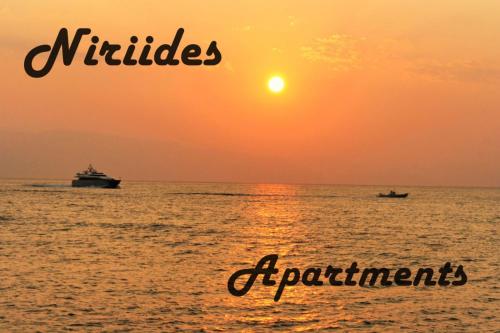 波多河丽Niriides Apartments的日落时分在海洋中的两艘船
