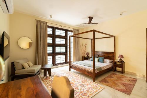 班加罗尔Luho 125的一间卧室配有一张天蓬床和一把椅子