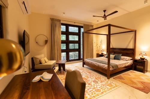 班加罗尔Luho 125的一间带天蓬床的卧室和一间客厅
