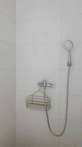 OpuzenHoliday house - Dvori Vlahovici的白色瓷砖墙上带淋浴头的淋浴