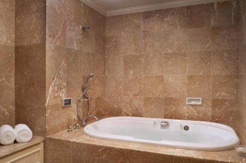 大阪大阪丽思卡尔顿酒店的大型浴室设有浴缸和淋浴。