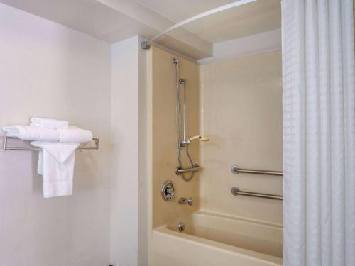 克莱门森Days Inn by Wyndham Clemson的带淋浴和毛巾浴缸的浴室