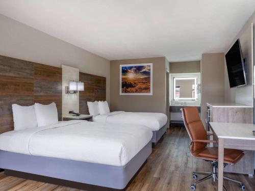 克莱门森Days Inn by Wyndham Clemson的酒店客房配有两张床和一张书桌
