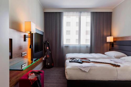 施韦夏特慕奇夕维也纳机场酒店的酒店客房设有两张单人床和吉他