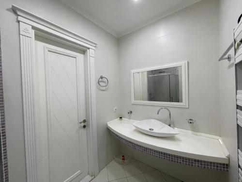 巴库Studio Apartment的白色的浴室设有水槽和镜子