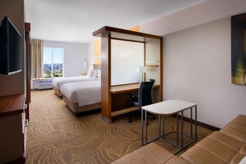 伯班克洛杉矶伯班克/市中心春季山丘套房酒店的酒店客房设有一间带一张床和一张书桌的卧室