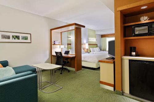 彭萨科拉万豪彭萨科拉春季山丘套房酒店的酒店客房配有一张床、一张书桌和一张沙发。