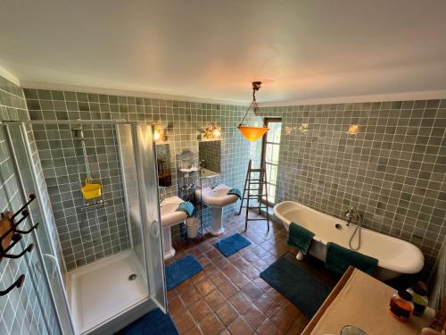 莱蓬特Le Mas Saint Jacques的浴室配有2个盥洗盆、浴缸和淋浴。
