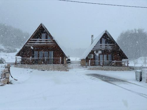 扎布利亚克Mountain Villas Žabljak的雪中三座房子