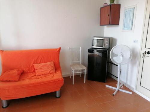 托里德欧索Torre Bella的客厅配有橙色沙发和微波炉