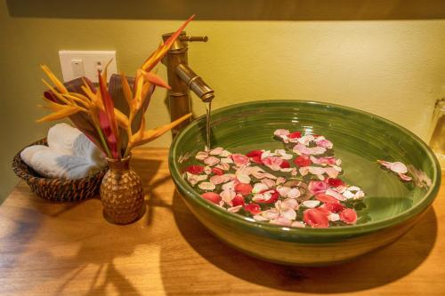 和平HỒ ĐÁ CỔ THIÊN LONG Hoa Le的桌上放着鲜花的绿色碗