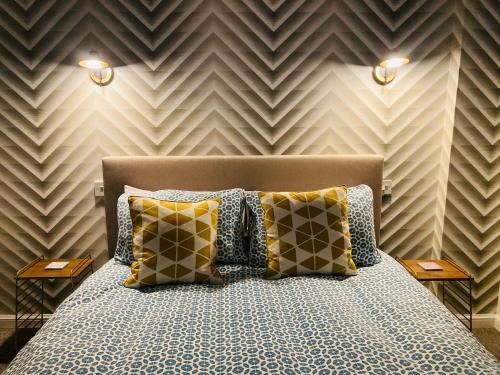 达尔基斯Glenarch House的一间卧室配有带枕头的床铺和墙壁
