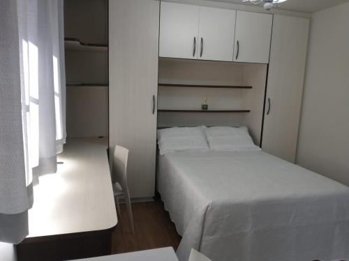 圣若泽杜斯皮尼艾斯Residencial Vitor Studio 5的一间小卧室,配有白色的床和白色的橱柜