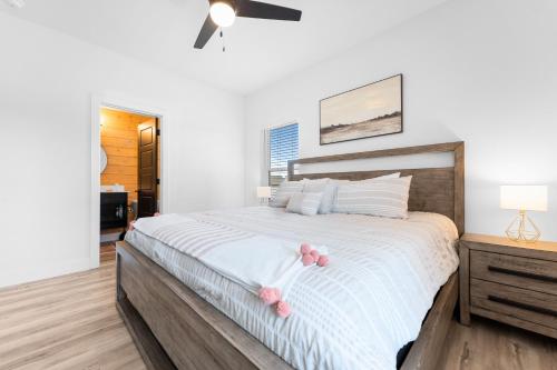 霍利斯特Windswept Cove home的一间卧室配有一张带粉红色鲜花的大床