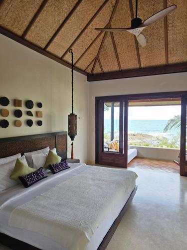 沙美岛Samed Tamarind Beach Resort的一间卧室设有一张床,享有海景