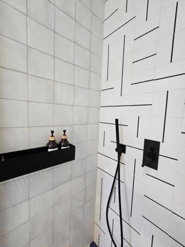 法鲁The Singular - Downtown Studio的白色瓷砖浴室,配有黑色架子