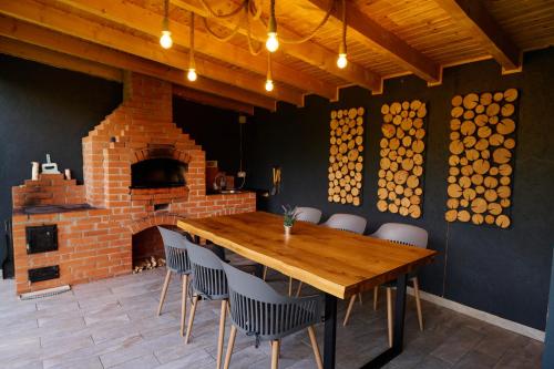 莫伊西德约斯RDT Guest House-Rai din Transilvania的一间带木桌的用餐室。 砖炉