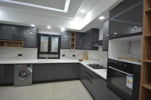 米多恩Diar Nader的厨房配有黑白橱柜和洗碗机。