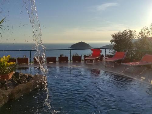 伊斯基亚Hotel Villa al Mare的一座带喷泉的游泳池,位于大海前