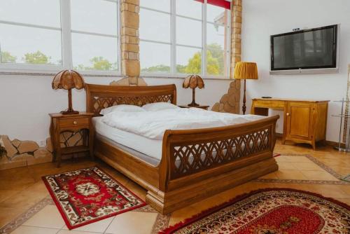 MurówDa Enzo的一间卧室配有一张大型木床和一台平面电视。