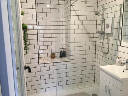 阿罗柴尔Heron’s View的带淋浴和盥洗盆的白色瓷砖浴室