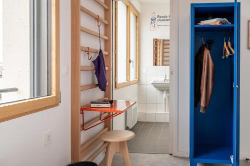 巴黎UCPA SPORT STATION HOSTEL PARIS的一间设有蓝色门和凳子的小浴室