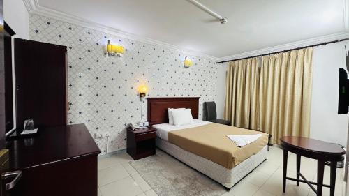 迪拜皇家王子酒店的配有一张床和一张书桌的酒店客房