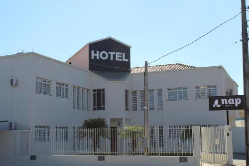 蓬塔格罗萨Nap Hotel的白色的建筑,上面有酒店标志