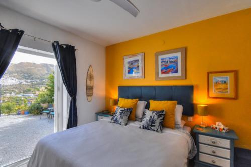 马拉加Casa Vista Maroma的一间卧室设有一张黄色墙壁和窗户的床