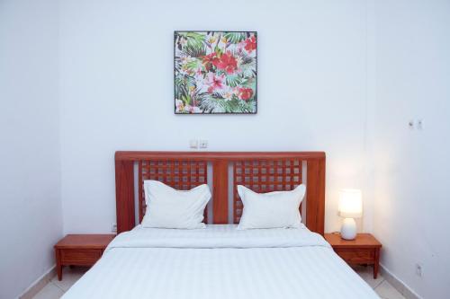 雅温得Résidence Vedette的一间卧室配有一张带两个白色枕头的大床