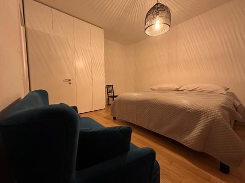VeytauxGrand Appartement Lumineux - STELLA Loft - À deux pas du Lac Léman的一间卧室配有一张床和一把椅子