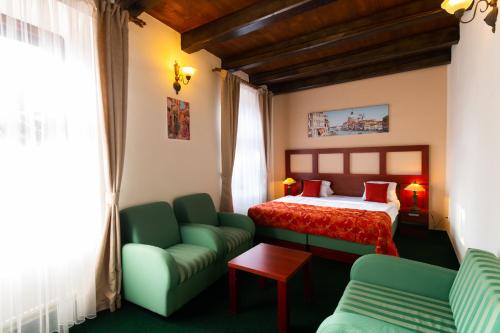 米库洛夫Vivaldi Apartments的酒店客房,设有一张床铺和一张绿色沙发