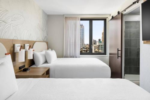 纽约SpringHill Suites by Marriott New York Manhattan Chelsea的酒店客房设有两张床和窗户。