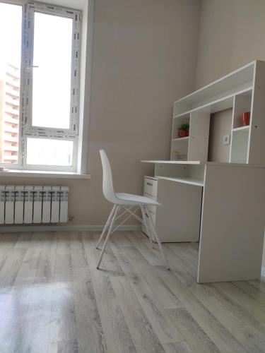 KirovoВ Астане новая комфортная квартира у реки и парка的一个空的白色办公室,有椅子和一张桌子