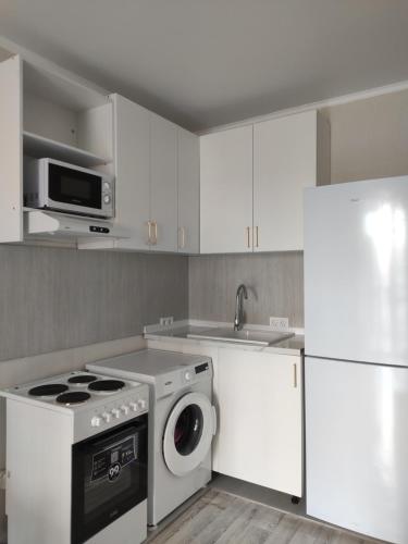 KirovoВ Астане новая комфортная квартира у реки и парка的厨房配有洗衣机和微波炉。