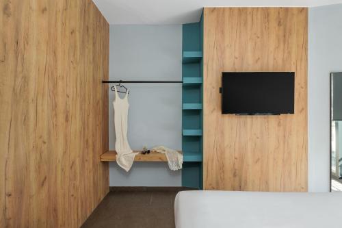 约阿尼纳THE URBANIST •inner city residences•的卧室设有壁挂式电视和床。