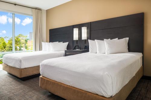 迪凯特Residence Inn by Marriott Decatur Emory Area的酒店客房设有两张床和大窗户。
